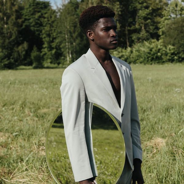 Man holding a difficult balance pose in a calm, minimalist environment.